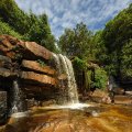 Водопад Кбаль Чхай (Kbal Chhay) - как и все пресноводные объекты Камбоджи сильно зависит от сезона. Сейчас, во время засухи, это исключительно красивый ручей, меж причудливого нагромождения скал, а не мутный поток бурлящей
            жидкости. Утреннее солнце делает особенно сочными и без того крикливые цвета мокрых камней.